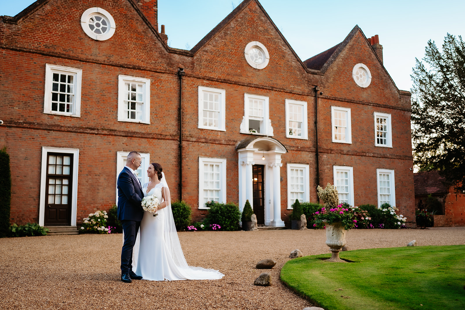Bride and groom portrait in front of Hutton Hall Georgian facade in Brentwood, Essex — editorial wedding photography by Lily & White