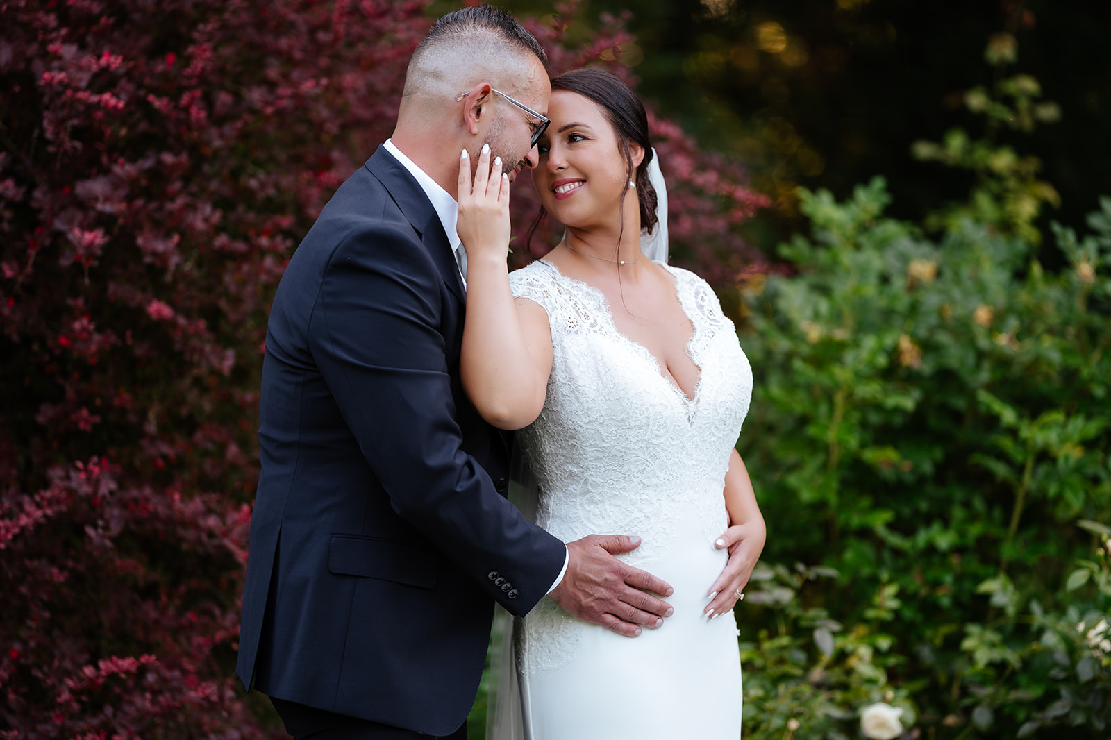 Intimate bride and groom moment beneath flowering trees at Hutton Hall in Brentwood — romantic wedding photography by Lily & White