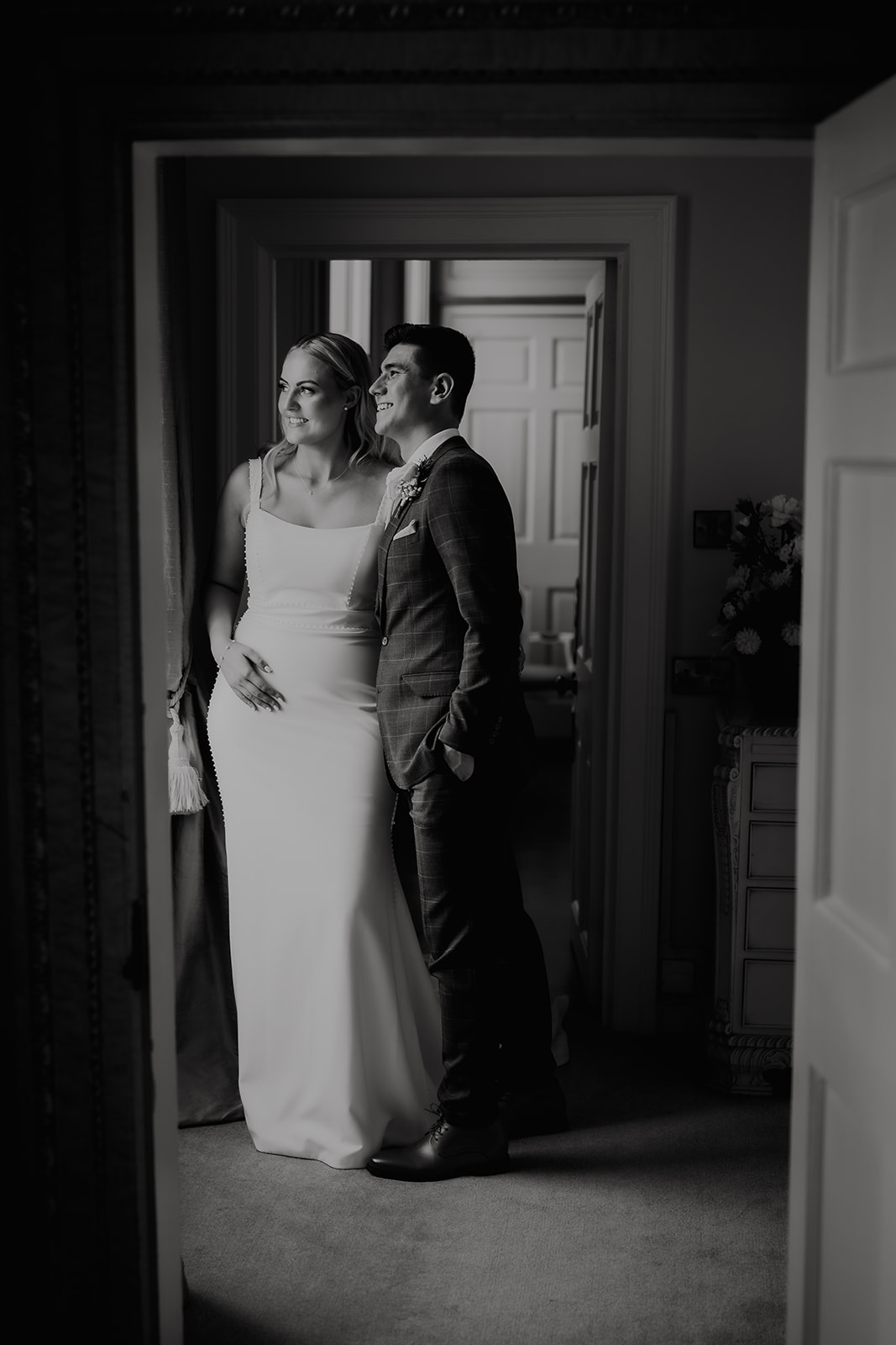 Bride and groom in dramatic black and white portrait in a period doorway at Gosfield Hall — artistic wedding photography by Lily & White