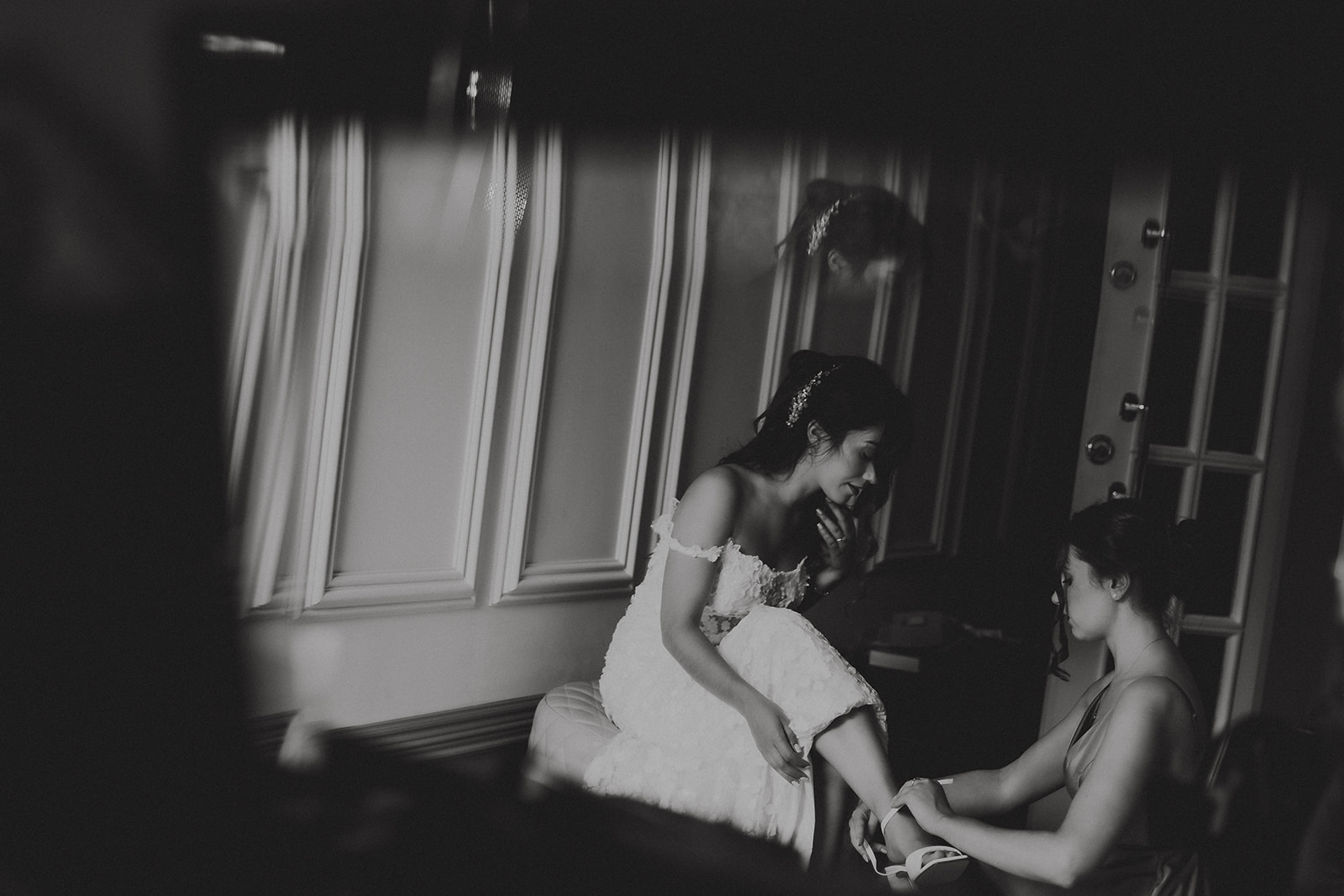 Bride getting ready with bridesmaids in natural window light at Friern Manor country hotel – candid documentary wedding photography by Lily & White