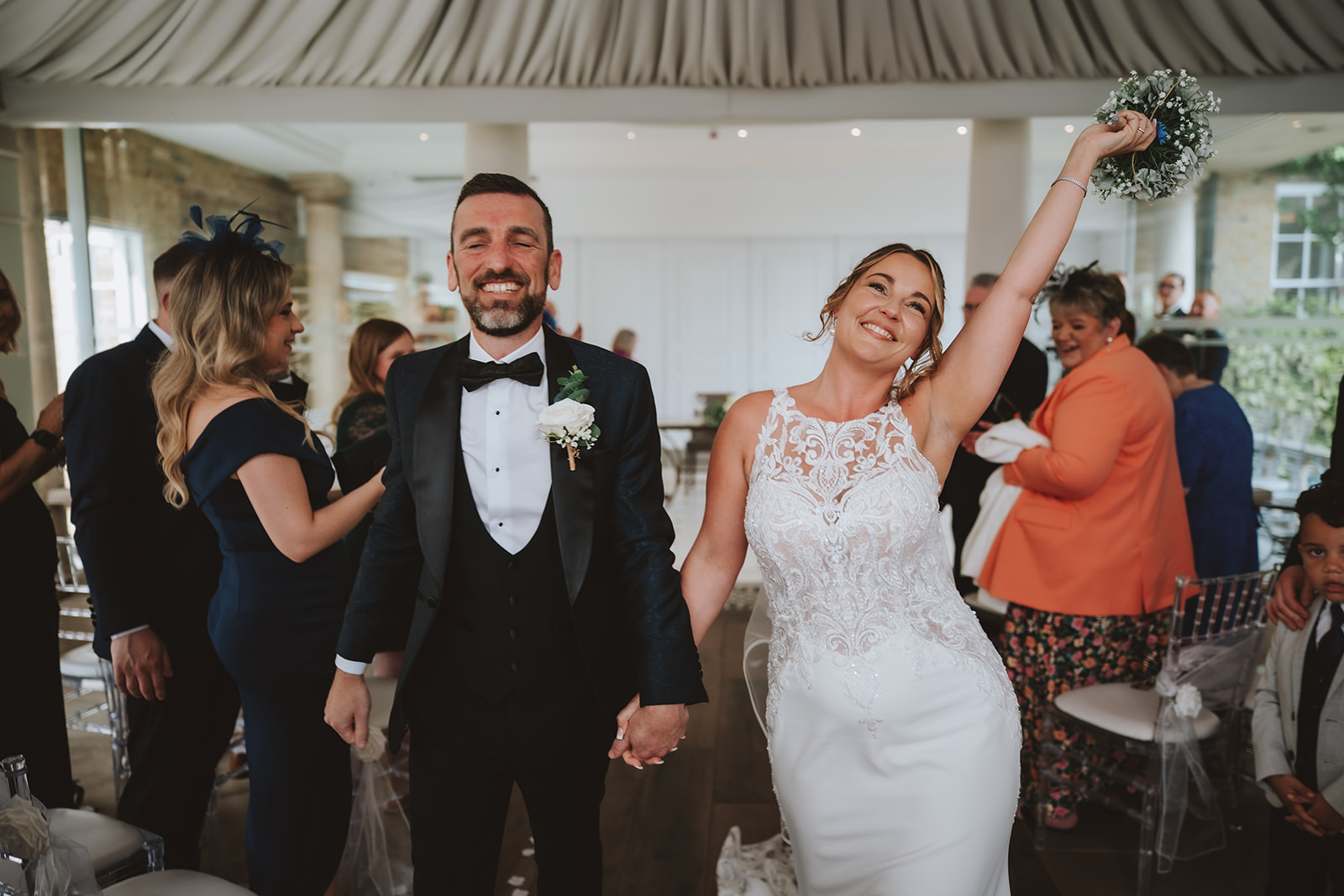 Bride and groom celebrating with at Friern Manor wedding in Brentwood — joyful documentary moment by Lily & White