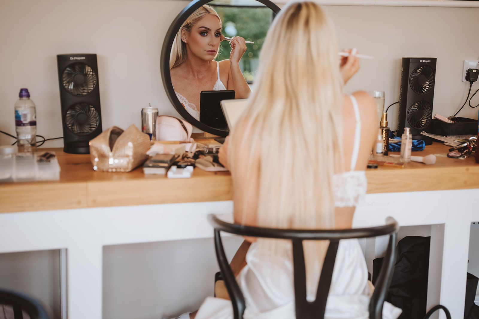 Bride getting ready at Primrose Hill Farm Cotswolds - Danielle applying makeup at the mirror on her wedding morning