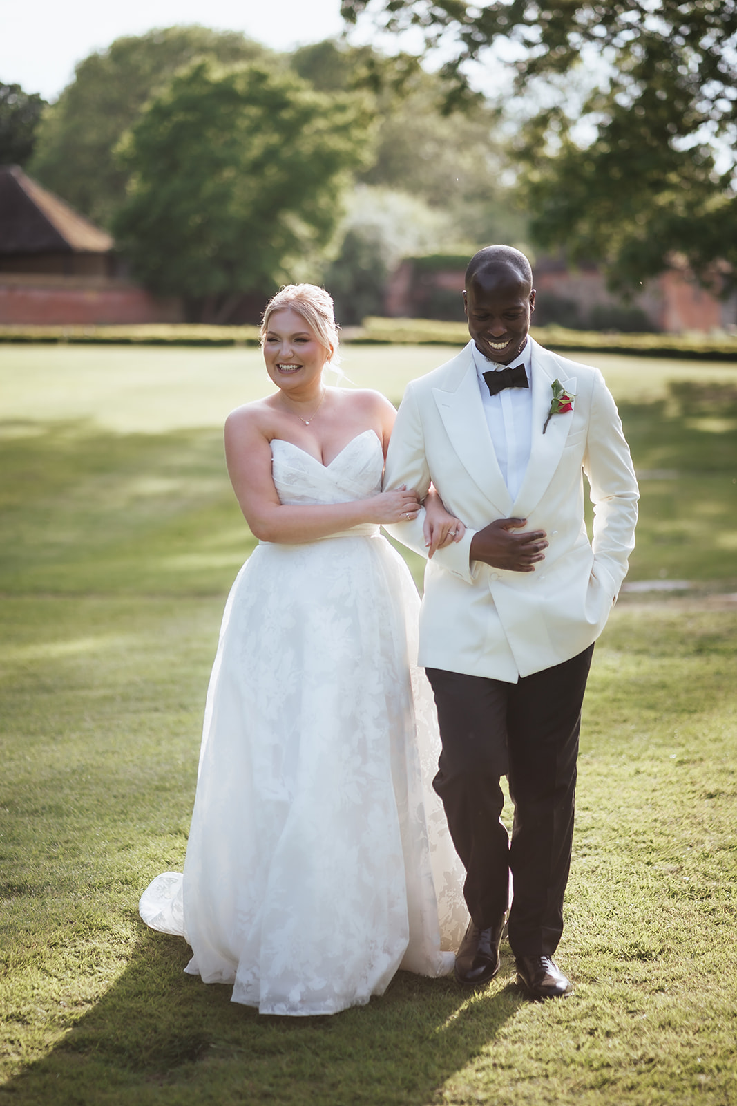 Jennifer and Toib laughing together in the grounds at Leez Priory, Essex on their wedding day, photographed by Tel, Lily & White Photography