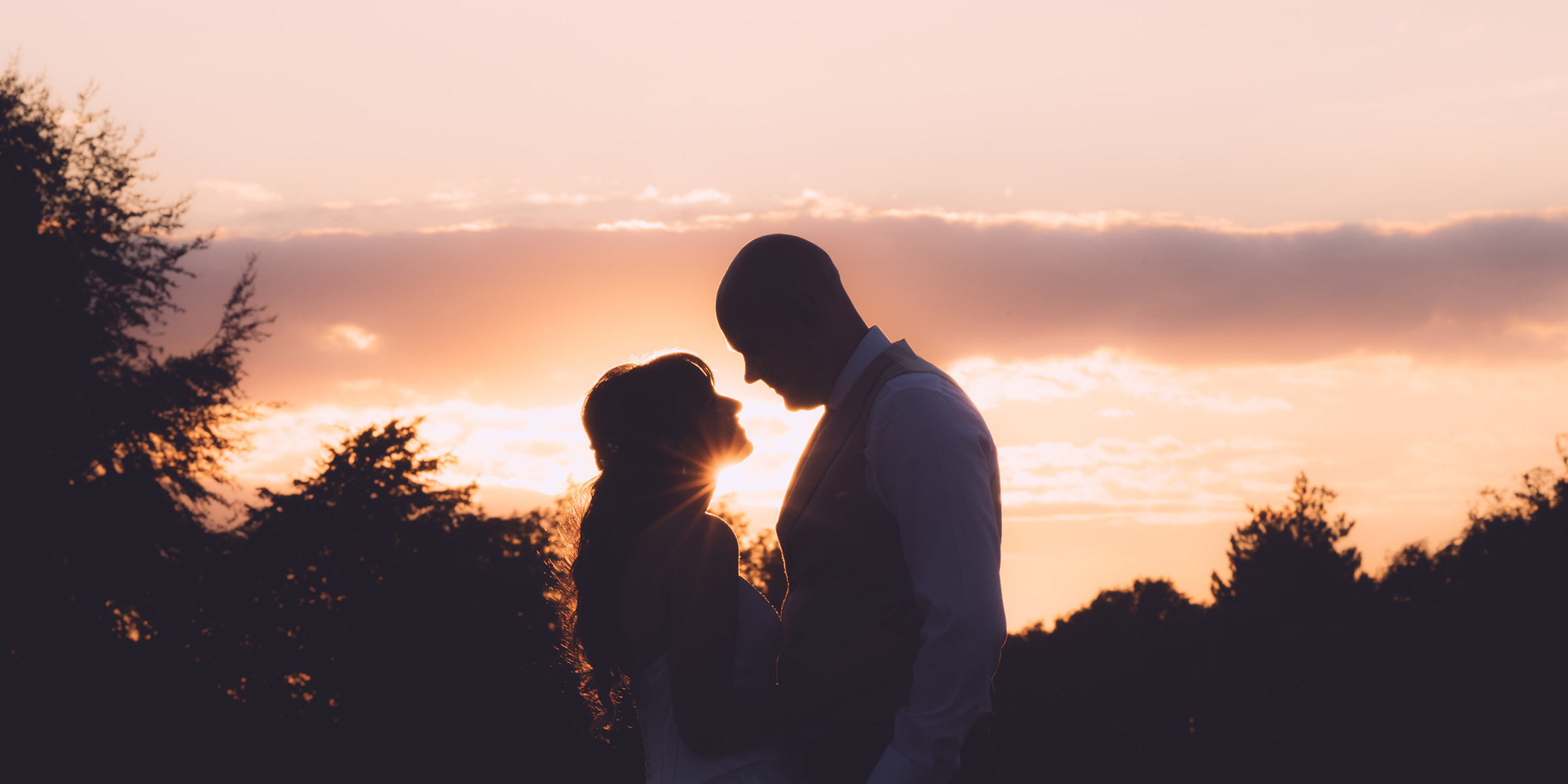 Couple silhouetted against the sunset at Blunsdon House