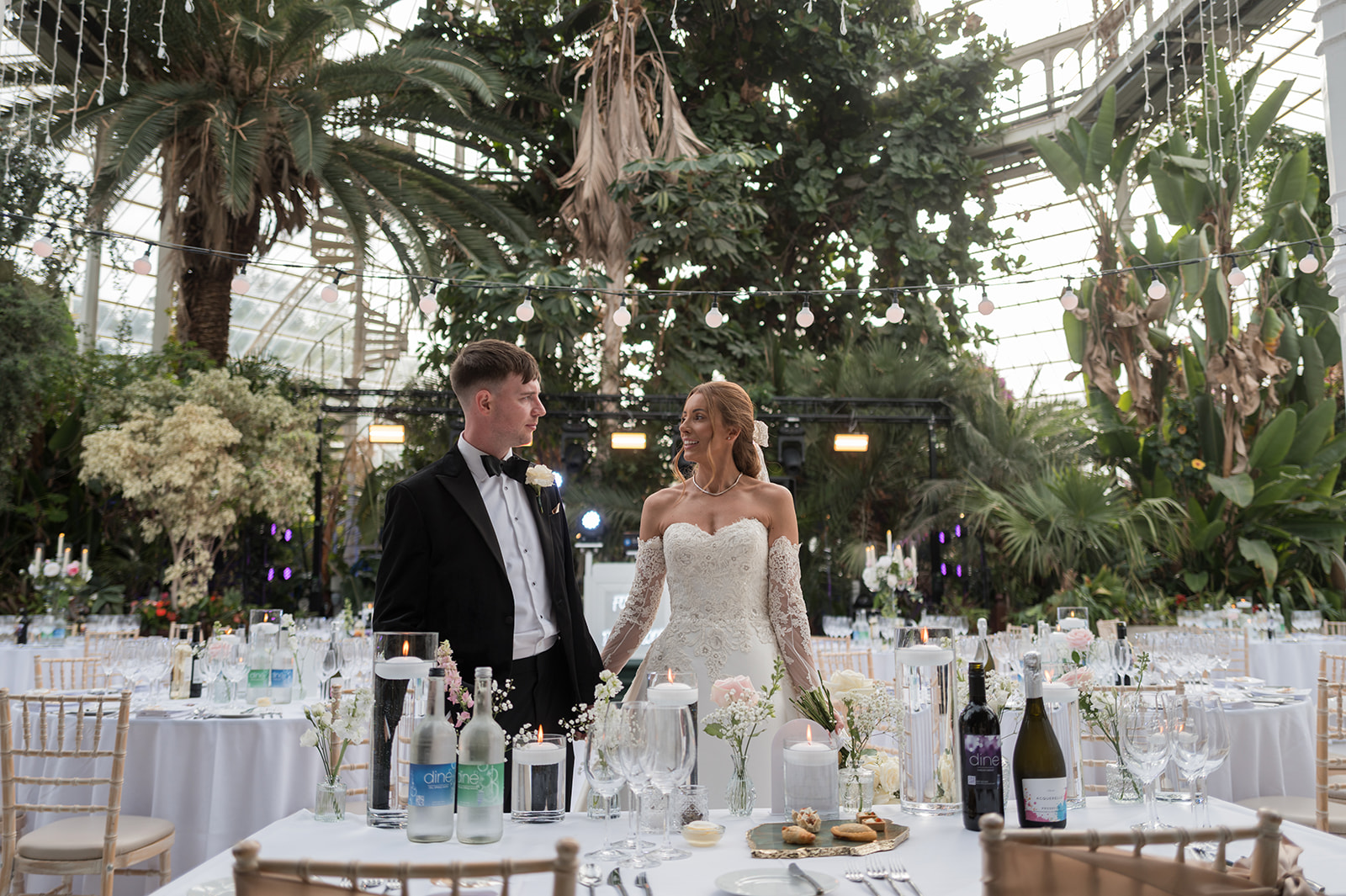 Heather and Charlie beneath the glass roof and palms inside Sefton Park Palm House