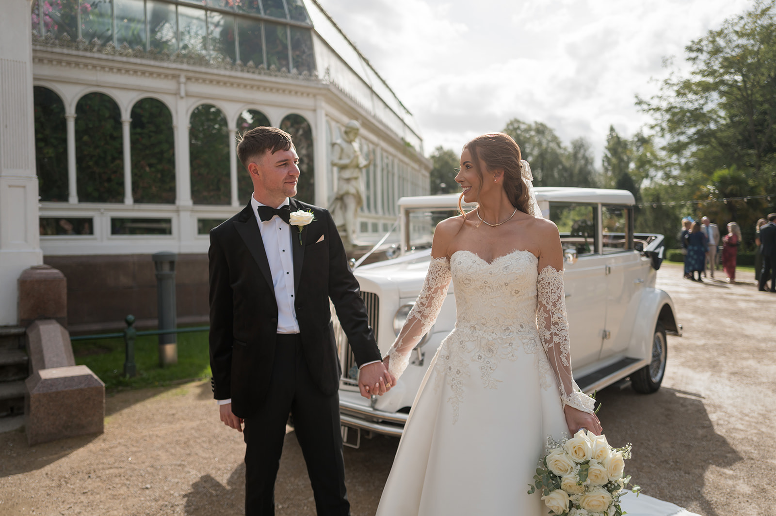 Heather and Charlie walking outside Sefton Park Palm House on their Liverpool wedding day